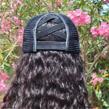 Load image into Gallery viewer, Black Distressed Ponytail & Messy Bun Baseball Cap back view on model with brown curly hair that is down. Pink flowers and green leaves in the background.