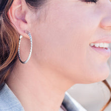 Load image into Gallery viewer, Twisted triple hoop silver earrings on model with long brown hair and jean jacket.  
