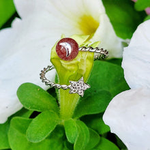 Load image into Gallery viewer, Picture of strawberry crystal adjustable ring on a green stem with white flowers.