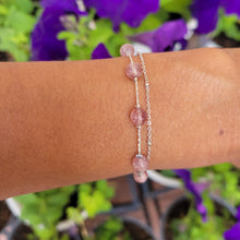 Load image into Gallery viewer, Picture of Double Strand Strawberry Crystal Sterling Silver Bracelet on a wrist with a purple flower background