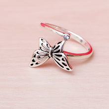 Load image into Gallery viewer, Picture of butterfly zircon adjustable sterling silver ring on tan surface.