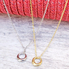 Load image into Gallery viewer,  Silver and Gold Geometric Charm Necklaces on a grey surface with a red mesh background.