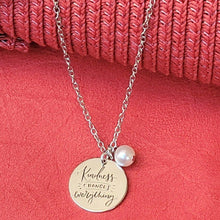 Load image into Gallery viewer, Picture of Kindness Changes Everything Inspirational Necklace on a red surface with a textured red background