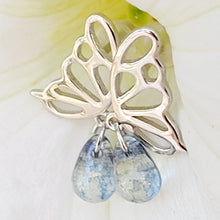 Load image into Gallery viewer, Picture of  Blue Stone Hollow Butterfly Sterling Silver Earrings with a white flower in the background.