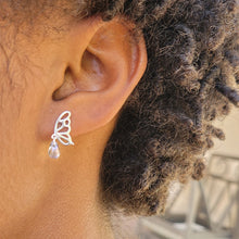 Load image into Gallery viewer, Picture of  Blue Stone Hollow Butterfly Sterling Silver Earrings on a model with short brown curly hair.