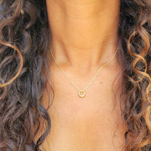 Load image into Gallery viewer, Gold Geometric Charm Necklaces on model with long brown curly hair and a black shirt.