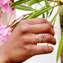 Load image into Gallery viewer, Picture of strawberry crystal adjustable ring on model's right ring finger with model grabbing branches and pink flowers in the background.