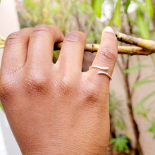 Load image into Gallery viewer, Picture of Geometric Adjustable Sterling Silver Ring on right pinky finger  against a brach with trees and leaves in the background