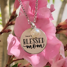 Load image into Gallery viewer, Picture of Blessed Mom Disc and Charm Necklace with white charm with pink flowers in the background.