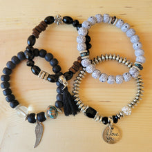 Load image into Gallery viewer, Black Tasseled Beaded Layering Bracelet with all four bracelets laid out separately on a wood background.
