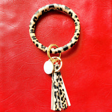 Load image into Gallery viewer, Leopard Print Key Ring Bracelet on red background.