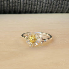 Load image into Gallery viewer, Picture of adjustable daisy ring on a tan tile with a black textured background