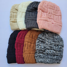 Load image into Gallery viewer, Ponytail & Messy Bun Knit Beanie front view on a white background.  Top row from left to right: cream, white, grey, and pink.   Bottom row from left to right: black, burgundy,  brown, black and white.