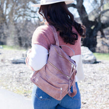 Load image into Gallery viewer, Model in white hat, pink and white sweater, and blue jeans wearing a pink convertible bag