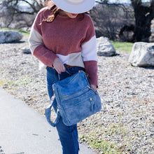 Load image into Gallery viewer, Model in a white hat and pink and white sweater and jeans holding a blue convertible bag