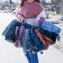 Load image into Gallery viewer, Model has a white and pink sweater and holding convertible bags.  From left to right, green, navy , pink, grey, black leopard, brown, black, blue