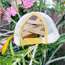 Load image into Gallery viewer, Mustard Distressed Ponytail &amp; Messy Bun Baseball Cap back view with pink flowers and green leaves in the background.
