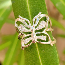 Load image into Gallery viewer, Adjustable butterfly ring wrapped around a green leaf.
