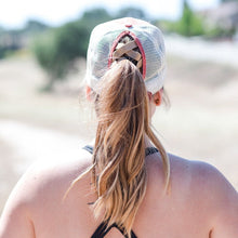 Load image into Gallery viewer, model is wearing red cap and a ponytail.  This is the back view.  She has a black tank top.  Background aer trees.
