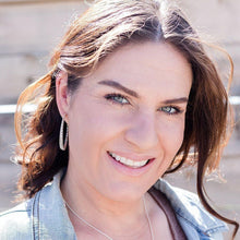 Load image into Gallery viewer, Twisted triple hoop silver earrings on model with long brown hair and jean jacket.  Grey background.
