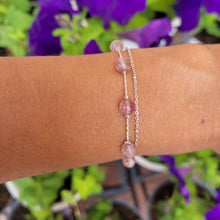 Load image into Gallery viewer, Picture of Double Strand Strawberry Crystal Sterling Silver Bracelet on a wrist with a purple flower background
