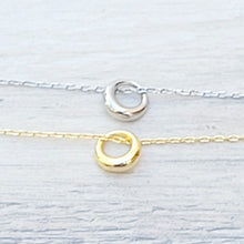 Load image into Gallery viewer, Silver and Gold Geometric Charm Necklaces on a grey surface.
