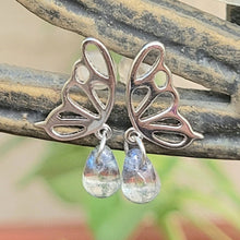 Load image into Gallery viewer, Picture of  Blue Stone Hollow Butterfly Sterling Silver Earrings on a brown and tan metal bar with leaves in the background. 
