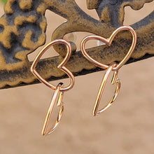 Load image into Gallery viewer, Asymmetrical double heart Sterling silver earring rose gold color on brown post with tan background.
