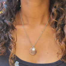 Load image into Gallery viewer, Mom Hustle Disc and Charm Necklace on a model with brown curly hair and a black shirt.
