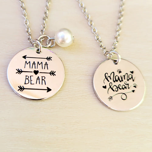 Mama Bear Disc Necklaces on a tan background. 