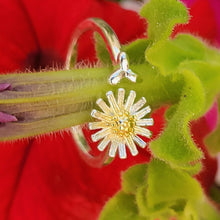 Load image into Gallery viewer, Picture of adjustable daisy ring wrapped around a green flower stem with red flowers in the back
